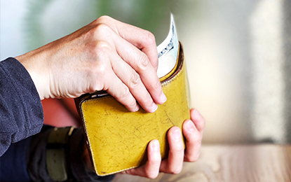 財布から丁寧にお札を選ぶ手元のイメージ